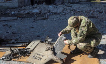 A police officer inspects parts of an unmanned aerial vehicle