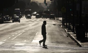 A pedestrian crosses a street in downtown Los Angeles on Dec. 3