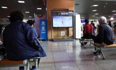 North Korea fired a ballistic missile without warning over Japan on October 4 for the first time in five years. People are seen here watching a TV broadcasting a news report on the missile