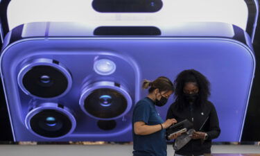 An employee assists a customer at the Apple store in Los Angeles on September 16.