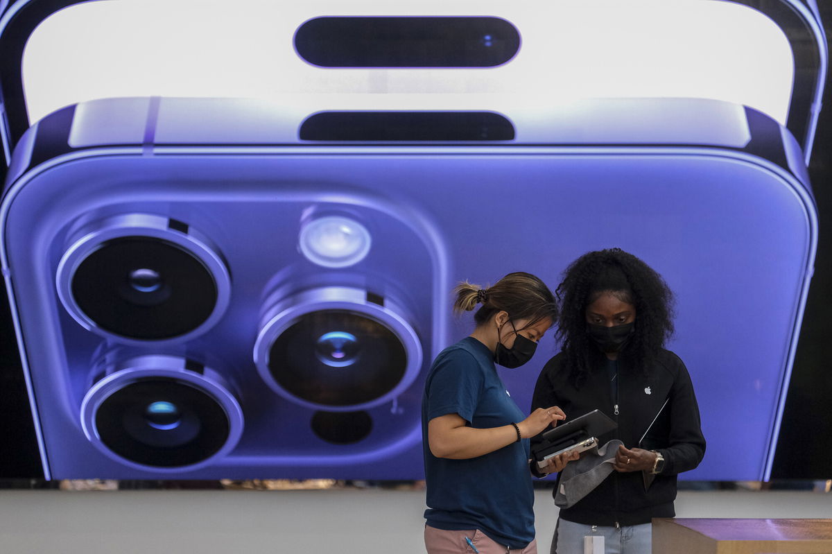 <i>Ringo Chiu/AP</i><br/>An employee assists a customer at the Apple store in Los Angeles on September 16.