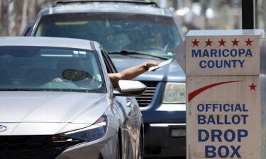 An association for retirees and an organization for Latino voters are seeking a temporary restraining order against a group they allege is coordinating a campaign of voter intimidation in Arizona. A voter is seen placing a ballot in a drop box in Phoenix