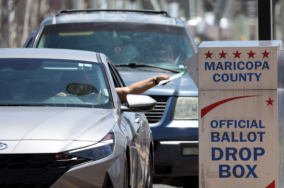 <i>Justin Sullivan/Getty Images</i><br/>A voter places a ballot in a drop box outside of the Maricopa County Elections Department on August 2 in Phoenix