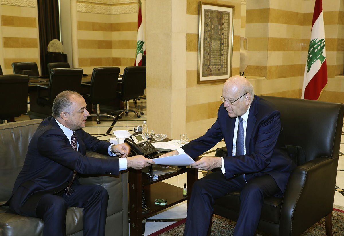 <i>Dalati Nohra/AP</i><br/>Lebanese Prime Minister Najib Makati (R) receives the final draft of the maritime border agreement between Lebanon and Israel from his deputy Elias Bou Saab (L) who leads the Lebanese negotiating team