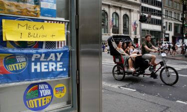 A pedicab rides past advertisements for the Powerball lottery on July 29 in New York. The Halloween Powerball drawing offers the ultimate treat: an estimated $1 billion jackpot.