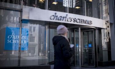 A pedestrian passes in front of a Charles Schwab Corp. bank branch in downtown Chicago