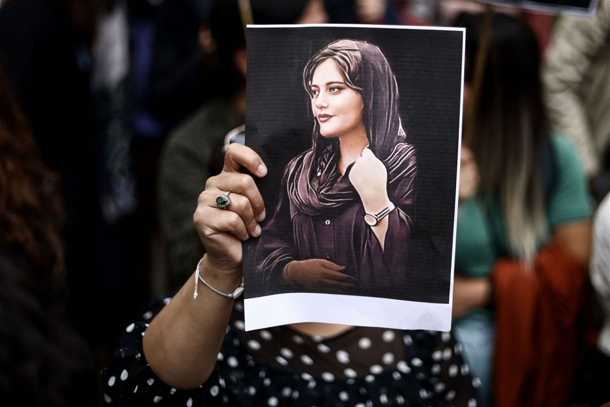 <i>Kenzo Tribouillard/AFP/Getty Images</i><br/>A protester holds a portrait of Mahsa Amini during a demonstration in her support in front of the Iranian embassy in Brussels on September 23.
