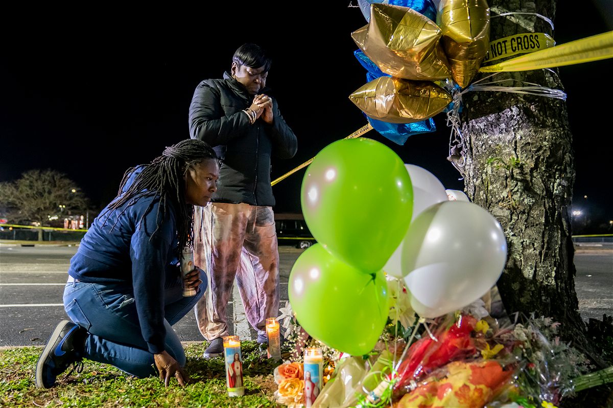 CHESAPEAKE, VA - NOVEMBER 23: Lashana Hicks (L) joins other mourners at a memorial for those killed in a fatal shooting at the Chesapeake Walmart Supercenter on November 23, 2022 in Chesapeake, Virginia. Six people, including the suspected gunman, are dead following the Tuesday night shooting.  (Photo by Nathan Howard/Getty Images)