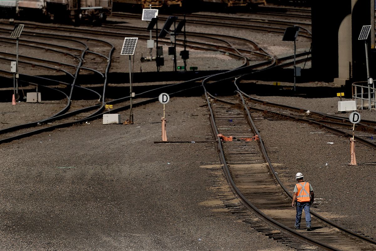 <i>Charlie Riedel/AP</i><br/>A worker walks along tracks at a BNSF rail yard