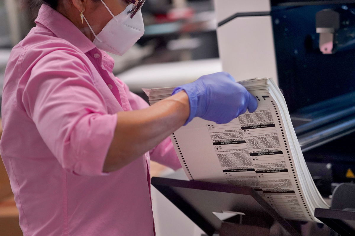 <i>Matt York/AP</i><br />An election worker removes tabulated ballots from the machine inside the Maricopa County Recorders Office on November 10 in Phoenix.