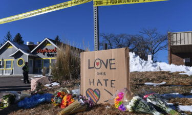 Bouquets of flowers and a sign reading "Love Over Hate" are left near the LGBTQ nightclub where at least 5 people were killed on November 20