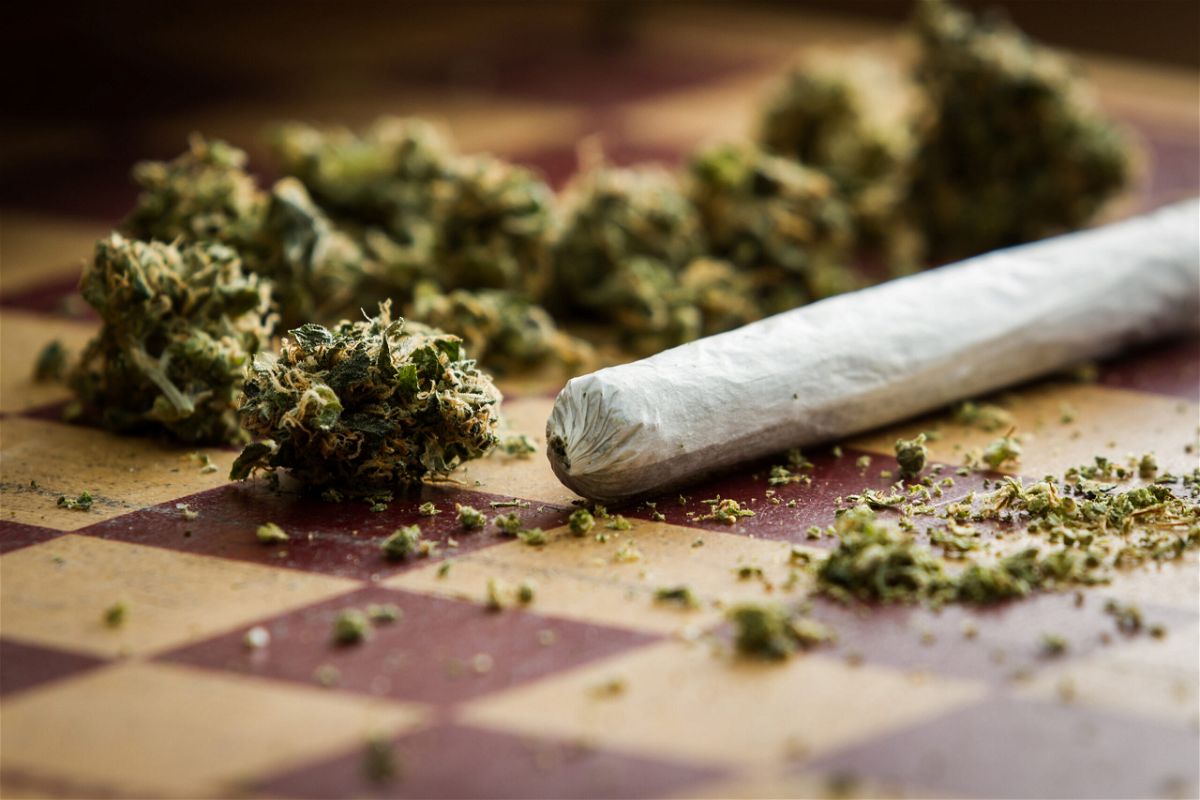 closeup of marijuana joint and buds on a checkerboard table with a shallow depth of field