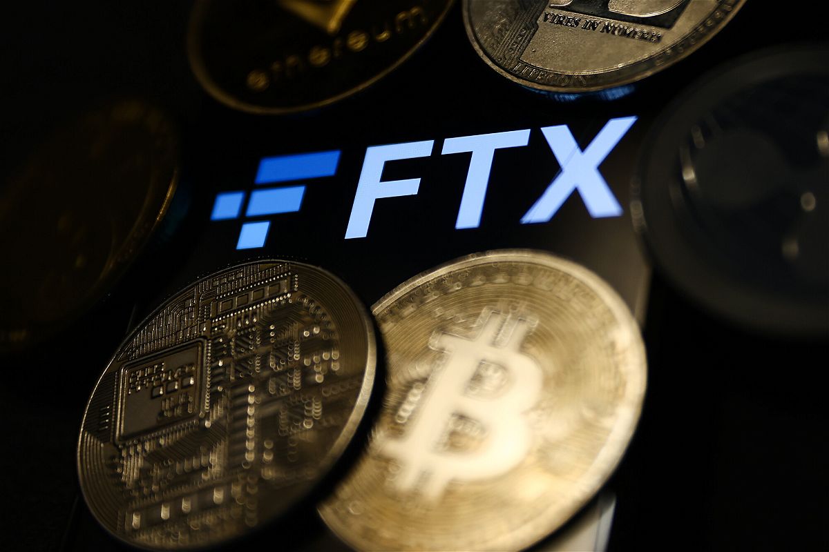 <i>Jakub Porzycki/NurPhoto/Getty Images</i><br/>An FTX logo is displayed on a phone screen and representation of cryptocurrencies are seen in this illustration photo taken on November 14.