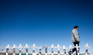 Tyler Vielie walks past crosses with the names of the victims of the Columbine High School shooting next to the Columbine Memorial on April 20