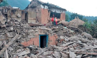 People outside the ruins of collapsed houses in the district of Doti after an earthquake struck Nepal on November 9.