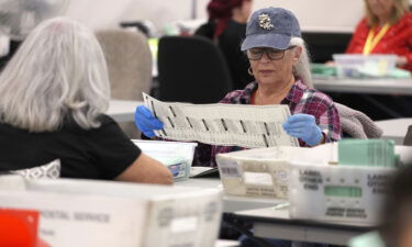 Election workers open mail in ballots at the Maricopa County Tabulation and Election Center on November 11