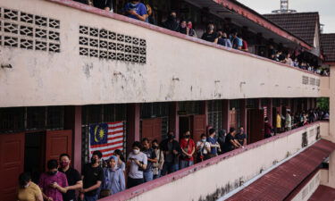 Voters wait in line at a polling station during the 15th general election in Kuala Lumpur