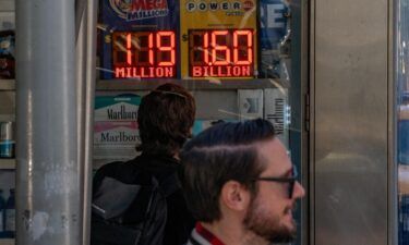 A person looks at a digital billboard advertising Powerball's Jackpot of 1.6 billion dollars in New York City