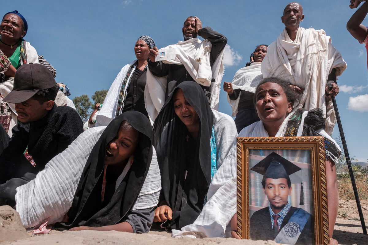 <i>EDUARDO SOTERAS/AFP/Getty Images</i><br/>Tigrayans grieve by a mass grave in the city of Wukro