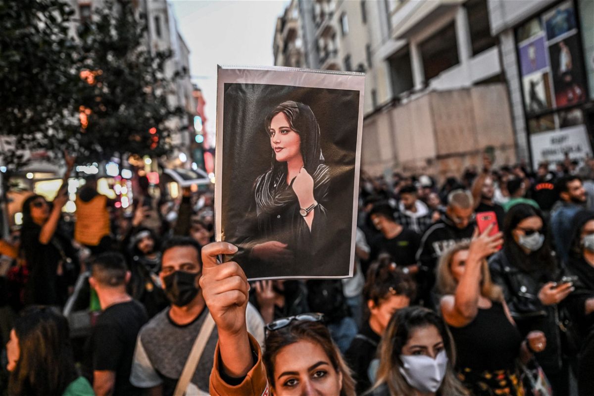 <i>Ozan Kose/AFP/Getty Images</i><br/>A protester holds a portrait of Mahsa Amini during a demonstration in Tehran on September 20.
