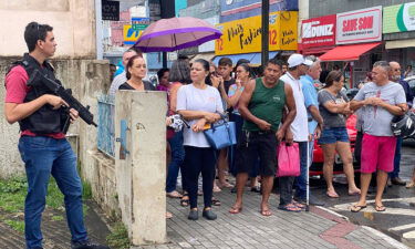 Local residents gather outside the police station where the alleged perpetrator of two school shootings is being held in Aracruz.