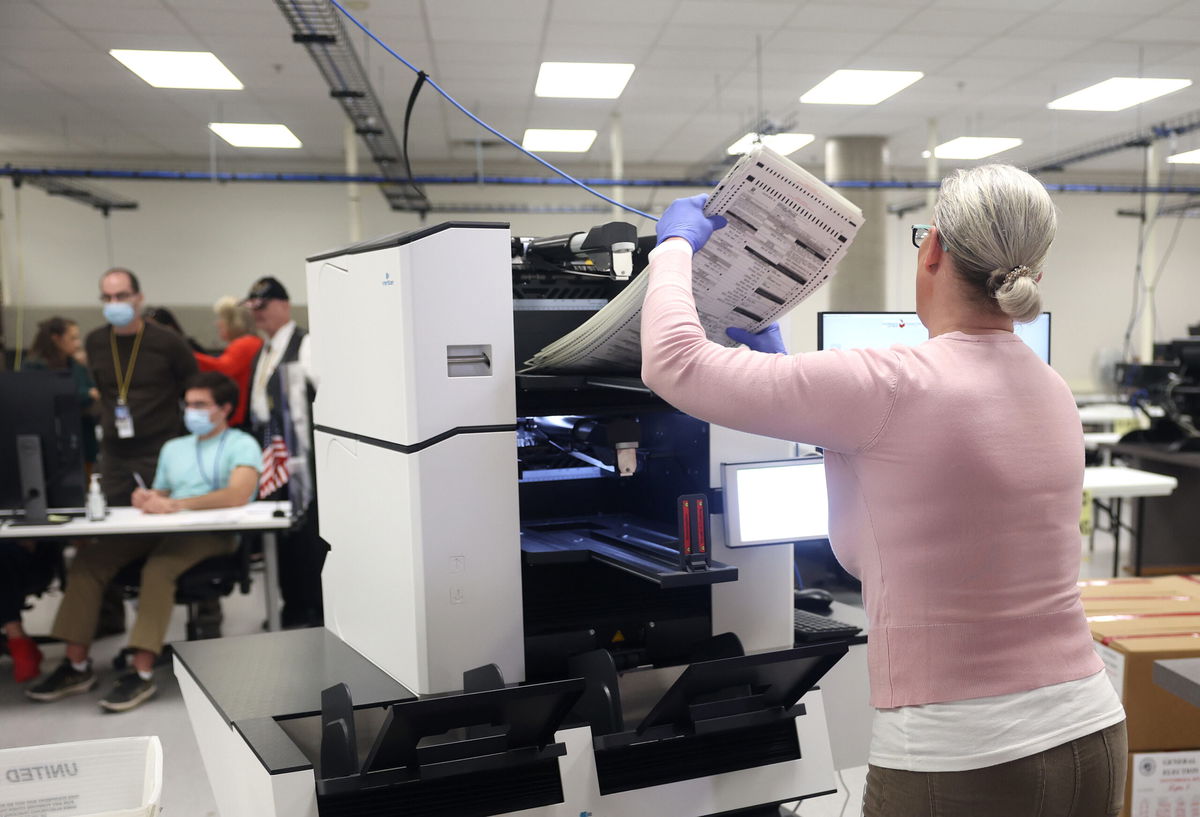 <i>Justin Sullivan/Getty Images</i><br/>An election worker inserts a stack of ballots into a scanning machine at the Maricopa County Tabulation and Election Center on November 10 in Phoenix