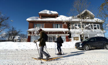 People snowshoe through snow covered streets in Buffalo