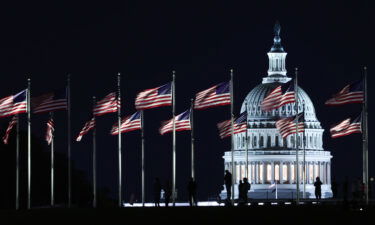 The Capitol building is seen through the American flags in Washington DC on October 20. Democrats will keep their narrow Senate majority for the next two years.