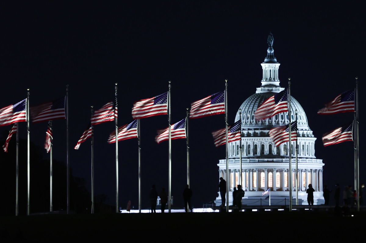 <i>Jakub Porzycki/NurPhoto/Getty Images</i><br/>The Capitol building is seen through the American flags in Washington DC on October 20. Democrats will keep their narrow Senate majority for the next two years.