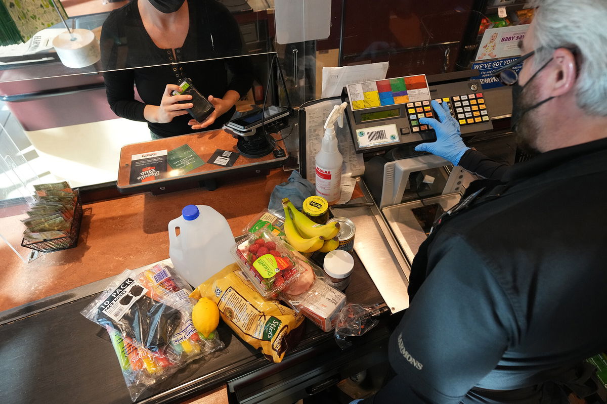 <i>George Frey/Bloomberg/Getty Images</i><br/>A cashier assists a customer at a checkout counter at Harmons Grocery store in Salt Lake City