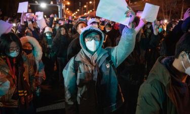 Demonstrators hold up blank sheets of paper during a protest in Beijing on November 28.