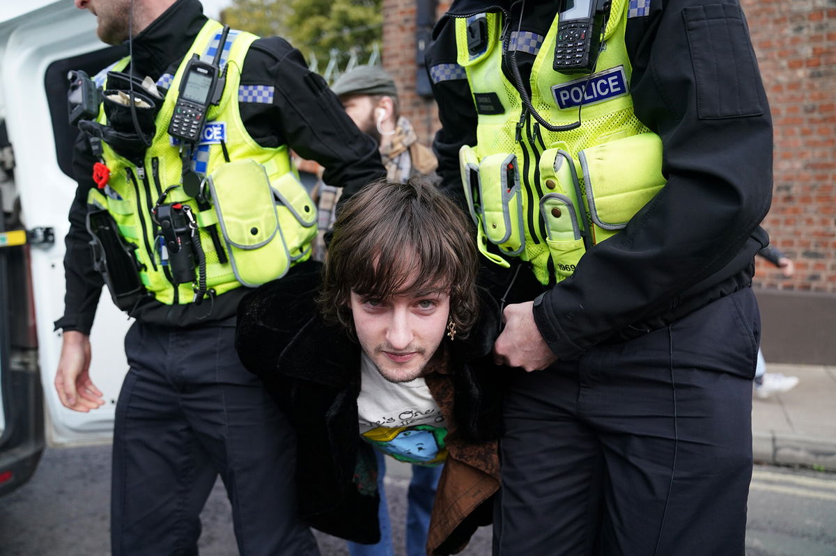 <i>Jacob King/PA Images/Getty Images</i><br/>Police detained a protester (center) after he appeared to throw eggs at the British monarch and Queen Consort.