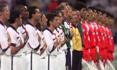 The players stand for the national anthems.