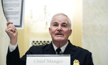 U.S. Capitol Police Chief J. Thomas Manger holds up a statutory congressional security information report while testifying during the Senate Rules and Administration Committee oversight hearing on January 5