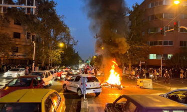 A police motorcycle burns during a protest over the death of Mahsa Amini