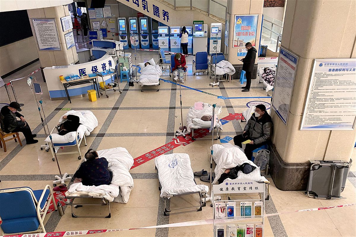 <i>Noel Celis/AFP/Getty Images</i><br/>Covid patients lie in the lobby of a hospital in the megacity of Chongqing as space in wards runs out.