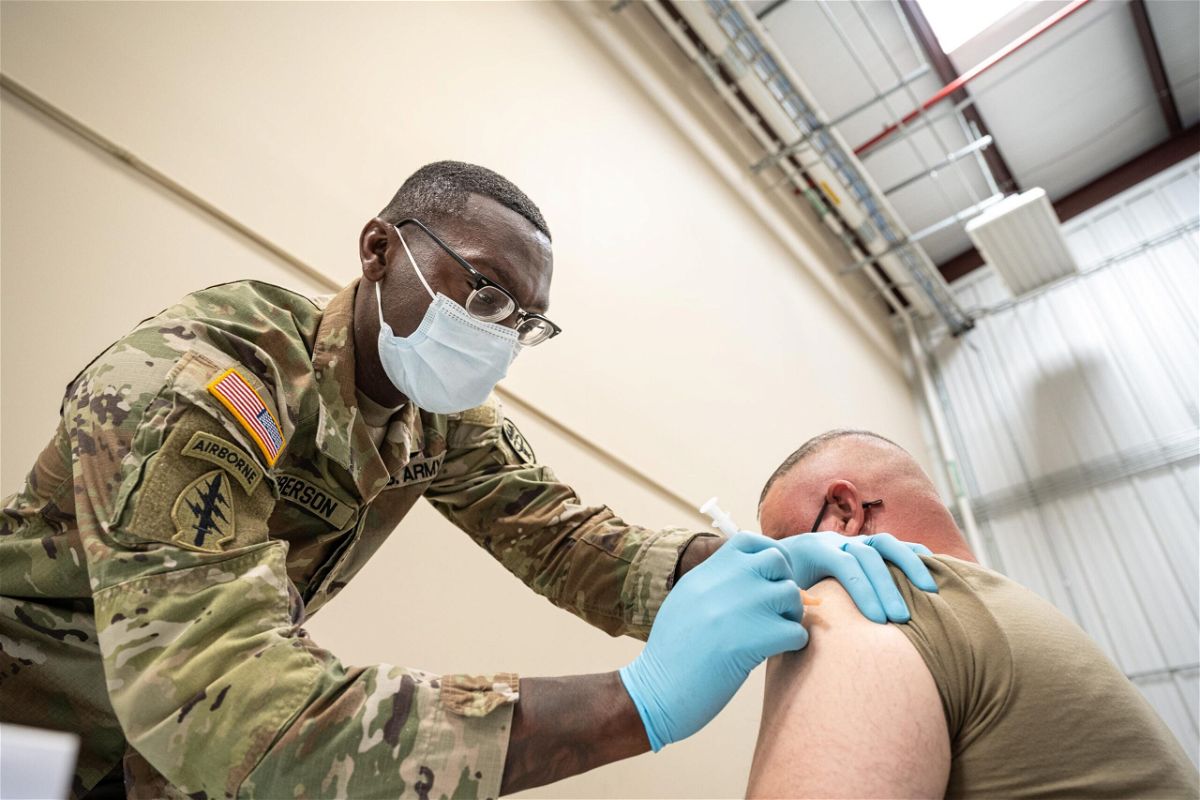 <i>Jon Cherry/Getty Images</i><br/>Sergeant First Class Demetrius Roberson administers a Covid-19 vaccine to a soldier on September 9