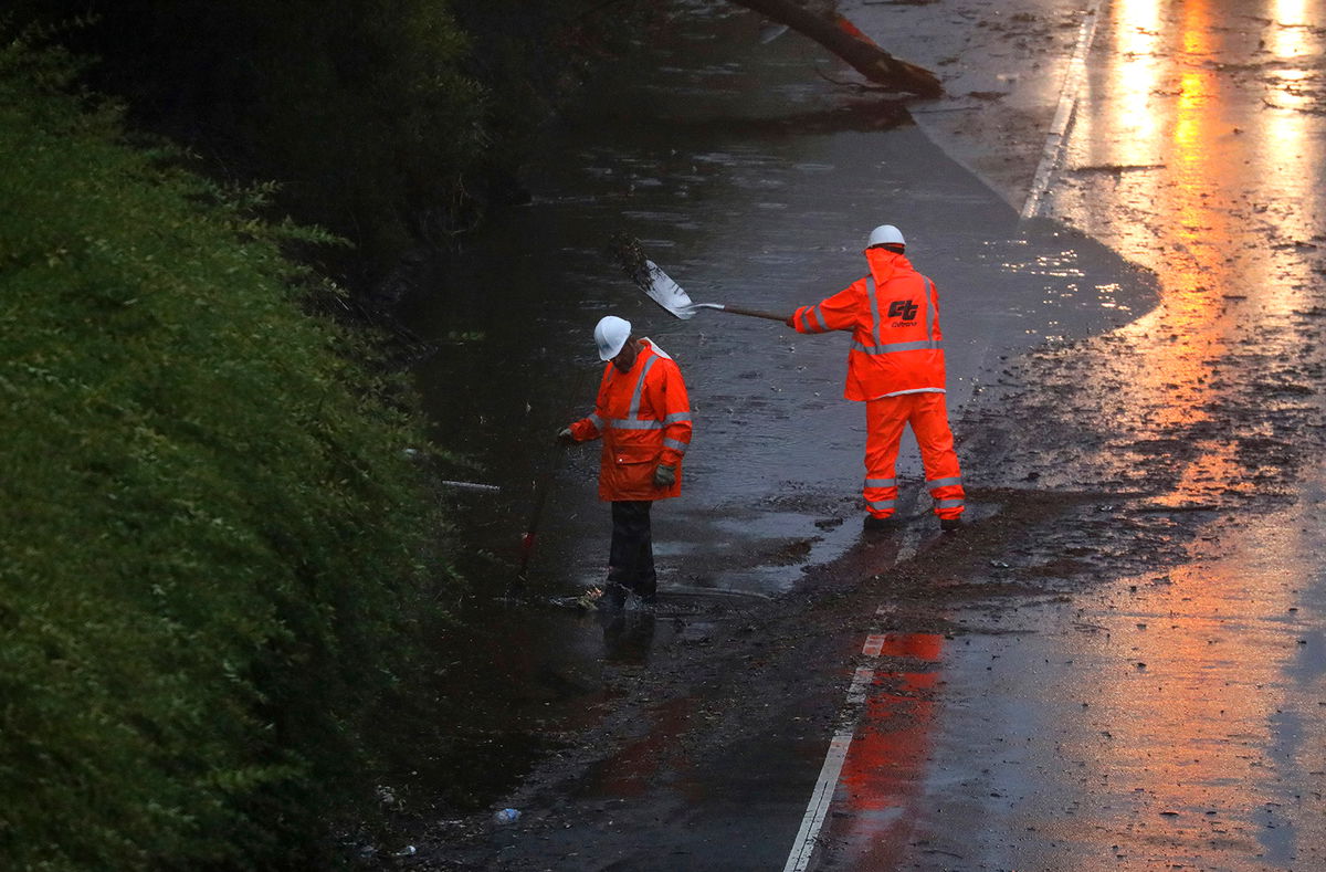 <i>Aric Crabb/AP</i><br />A crew works Tuesday to clear a flooded portion of California's northbound Highway 13 in Oakland.