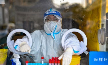 A health worker waits for people to take swab samples to test for Covid-19 in Shanghai on December 19.