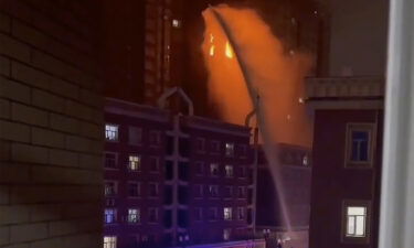 Firefighters spray water on a fire at a residential building in Urumqi