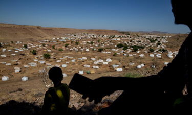 A Tigrayan man looks for cellular phone service on a mountain overlooking Um Rakuba refugee camp in eastern Sudan in January.