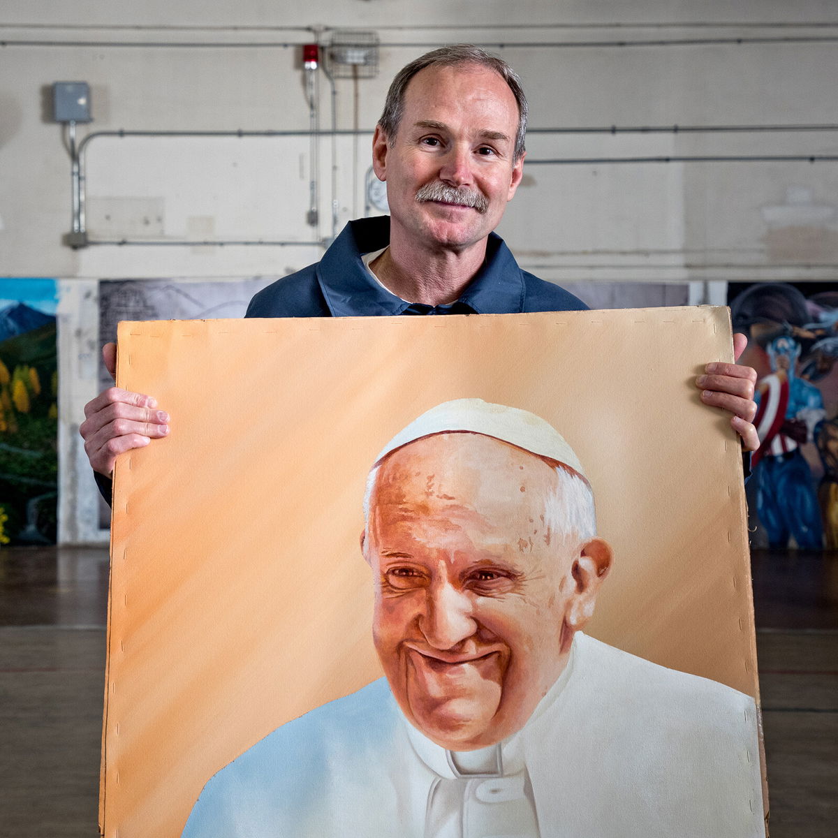 <i>Peter Merts</i><br/>One of phogographer Peter Merts' subjects with an acrylic painting of Pope Francis in 2016. The man was released from prison three years later and now owns a property where he builds micro-homes for homeless people and those who have been released from prison.