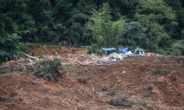 Malaysian officials inspect the site damaged after the landslide.