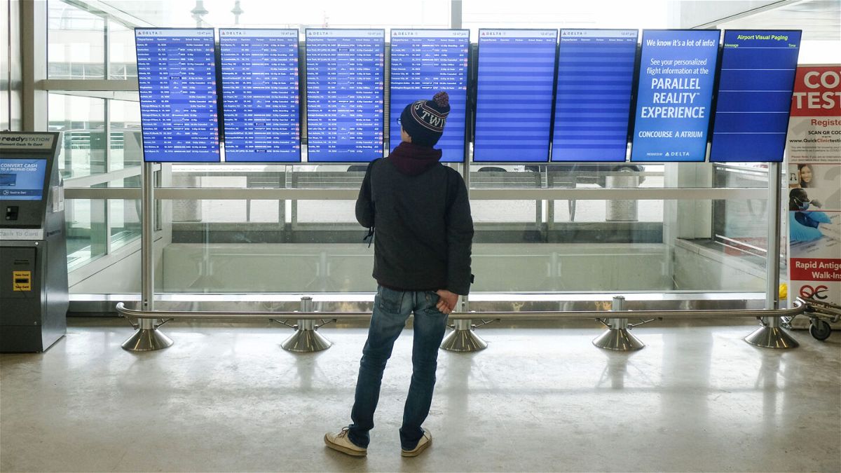 <i>Matthew Hatcher/Getty Images</i><br/>A holiday traveler looks at flight information at the Detroit Wayne County Metro Airport on December 24 in Detroit.
