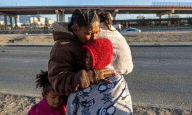 Venezuelan immigrant Yaneisi Martinez weeps while embracing her three children after Texas National Guard troops and state police blocked a popular border crossing area on December 20