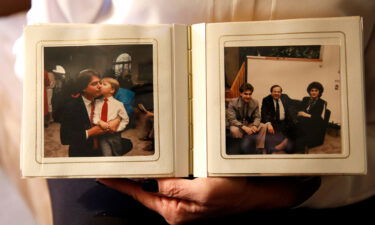 Pamela DiSarro holds a photo album with a photograph of her husband