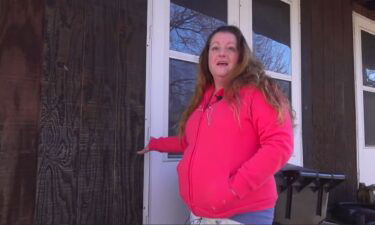 Tina Abbacchi shows the area where an arrow hit her home.