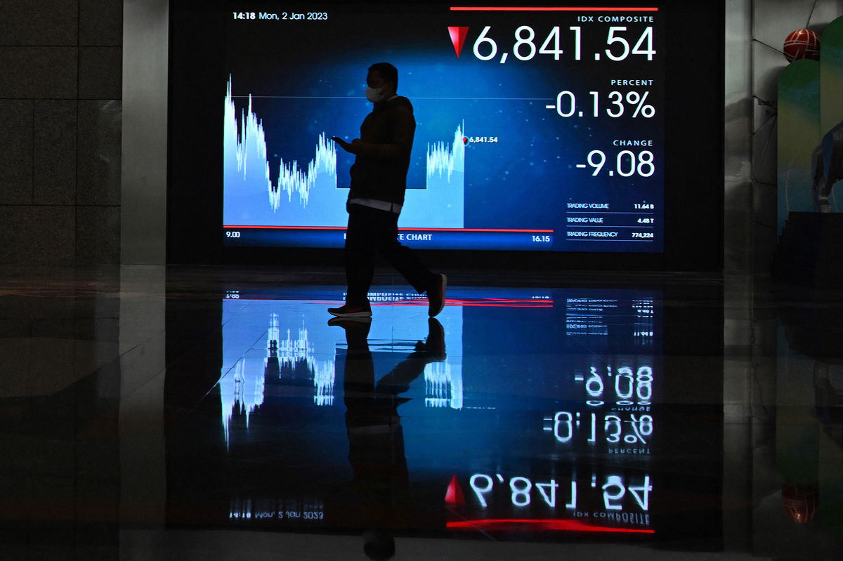 <i>Adek Berry/AFP/Getty Images</i><br/>A man walks next to a screen at the Indonesia Stock Exchange in Jakarta on January 2.