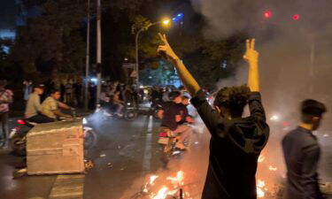 A demonstrator raises his arms and makes the victory sign during a protest in Tehran on September 19