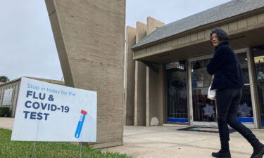 A sign advertising flu and Covid-19 testing is seen in front of a pharmacy in Orlando